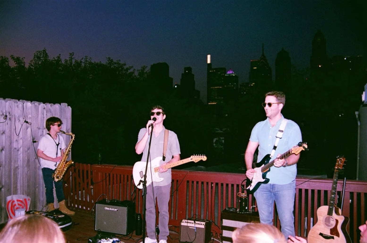 Lenny Miller performing with his band on a rooftop at night